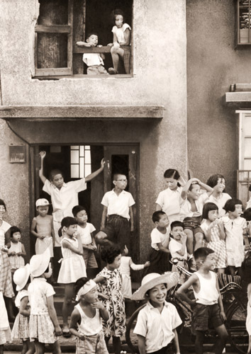 アパート街の人気者(べっこう飴売りを見送るアパート街の子供たち） [渡辺秀夫, フォトアート 1955年7月号より] パブリックドメイン画像 