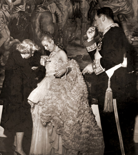 ペロン将軍とブエノスアイレスの劇場に出かける前に勲章をつけてもらうエヴァ夫人 [ジゼル・フロインド, 1950年, 栄光の「LIFE」展 1946-1955 時代の顔を衝くより] パブリックドメイン画像 