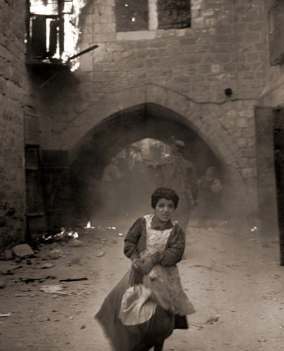 イスラエル建国からわずか数時間、ヨルダンのアラブ軍はエルサレム旧市街占領のためしらみつぶしの攻撃を開始した 戦火のなかを恐怖におののきながら逃げる少女 [ジョン・フィリップス, 1948年, 栄光の「LIFE」展 1946-1955 時代の顔を衝くより] パブリックドメイン画像 