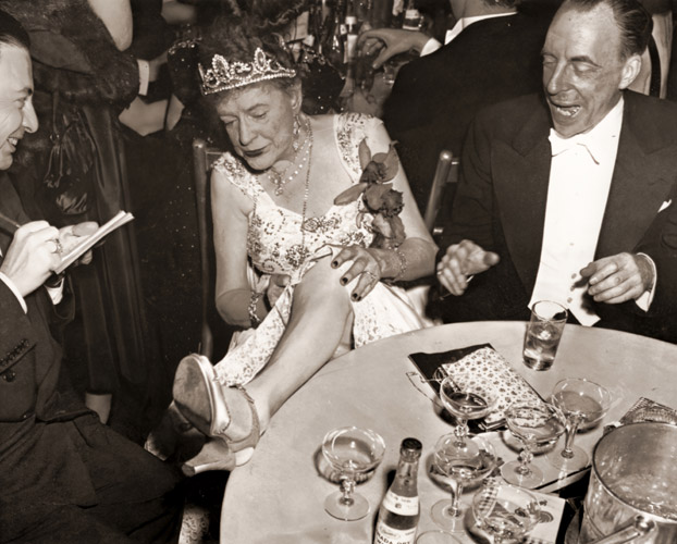 マルレーネ・ディートリッヒの脚とくらべてどう？メトロポリタン・オペラの初日の夜、ふざけてみせるフランク・ヘンダーソン夫人 [ウォルター・ケレハー, 1947年, 栄光の「LIFE」展 1946-1955 時代の顔を衝くより] パブリックドメイン画像 