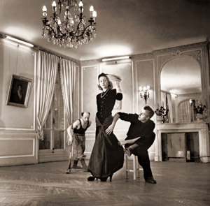 パリでのファッション・ショーを前に夫人のガウンを合わせるデザイナーのジャック・ファス すぐそばで床みがきの労働者が忙しく働いている [ニナ・リーン, 1946年, 栄光の「LIFE」展 1946-1955 時代の顔を衝くより]のサムネイル画像