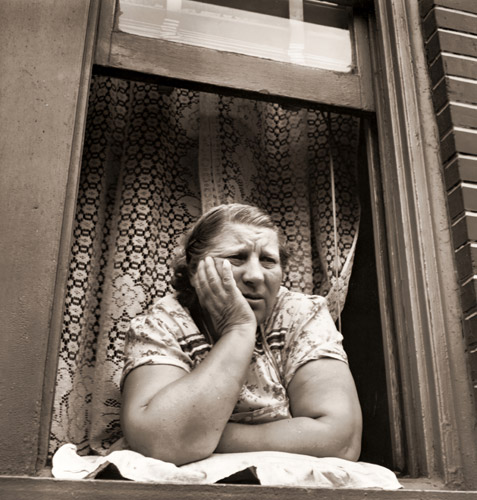 ブルックリンで家の窓から通りを眺める婦人 [エド・クラーク, 1946年, 栄光の「LIFE」展 1946-1955 時代の顔を衝くより] パブリックドメイン画像 