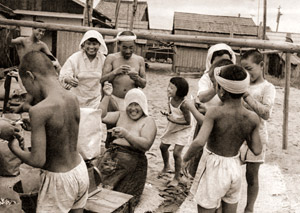 写真をもらって喜ぶ人達 [栗波繁, 日本カメラ 1956年1月号より]のサムネイル画像