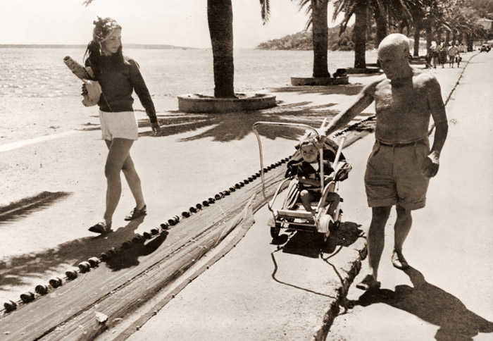海辺のピカソ（クロードが乗る乳母車を引くピカソ） [ロバート・キャパ, アサヒカメラ 1952年8月号より] パブリックドメイン画像 