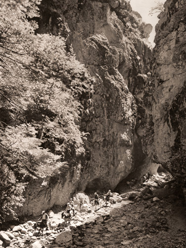秘められた峡谷（トンネルのような隘路を進む探検隊） [ラルフ・クレーン, アサヒカメラ 1952年9月号より] パブリックドメイン画像 
