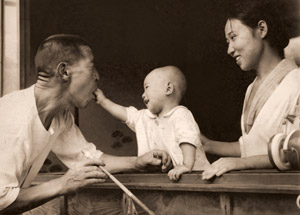 坊やがこんなに（おじいさんの口に氷砂糖を入れる赤ちゃん） [中島繁治, アサヒカメラ 1939年12月号より]のサムネイル画像
