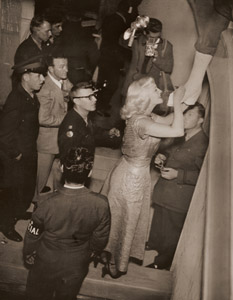 会場でアメリカ将兵の繃帯した脚に、乞われるままサインするマックスウェル [稲村隆正, アサヒカメラ 1951年1月号より]のサムネイル画像